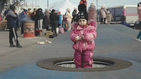 Lviv, Ukrayna - 15 Mart 2022: Ukrayna 'nın batısındaki Lviv kentindeki tren istasyonu yakınlarındaki doğu Ukrayna' dan tahliye edilenler. Sokakta duran küçük kız.