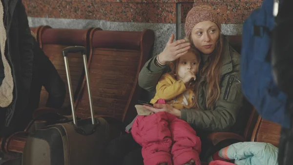 Lviv, Ukrayna - 15 Mart 2022: Rusya 'nın Ukrayna' ya düzenlediği insani yardım krizi. Ukraynalı mülteciler tren istasyonunda anne ve kızı. Çocuğunu sakinleştiren kadın.