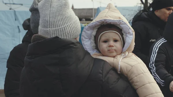 Lviv, Ukrayna - 15 Mart 2022: Kadın çocuğunu ellerinden tutuyor. Ukraynalı anne ve oğul mülteciler Lviv tren istasyonunda Avrupa 'ya kaçmak için tren bekliyor..