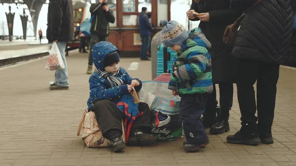 Lviv, Ουκρανία - 15 Μαρτίου 2022: Πορτρέτο δύο μικρών παιδιών προσφύγων από την Ουκρανία που παίζουν στο σιδηροδρομικό σταθμό. Πόλεμος μεταξύ Ουκρανίας και Ρωσίας. — Φωτογραφία Αρχείου
