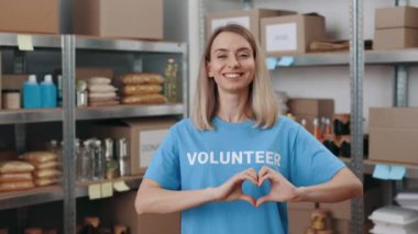 Gönüllü bir kadın elleriyle kalp sembolü yapıyor.