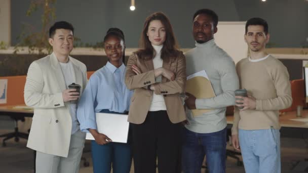 Portrét šťastné skupiny obchodníků, kteří stojí v kanceláři a dívají se na kameru se založenýma rukama. Multietničtí profesionální zaměstnanci pózující společně pro portrét firemního týmu, vedení. — Stock video
