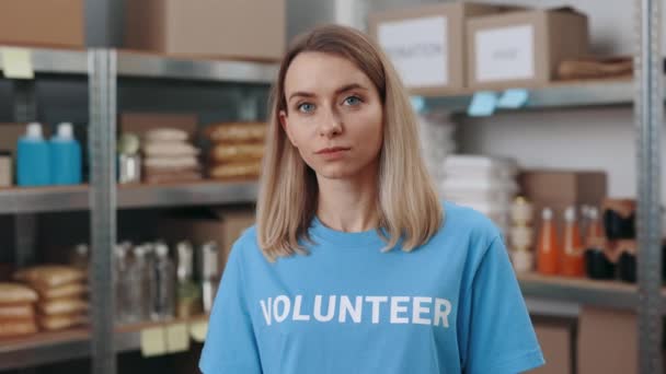 Junge freiwillige Helferin posiert im Lager der Lebensmittelbank — Stockvideo