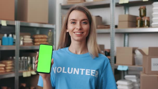 クロマキースクリーン付きスマートフォンを持つ女性ボランティア — ストック動画