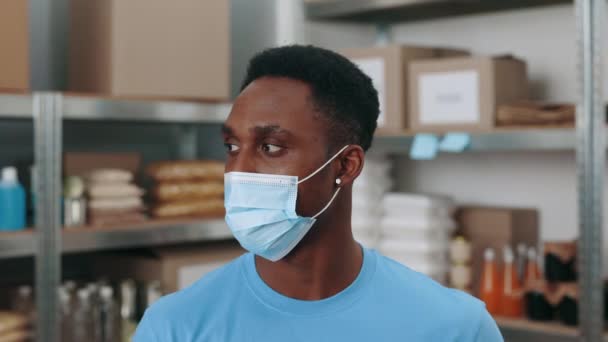 Hombre afroamericano con máscara facial posando en el banco de alimentos — Vídeos de Stock