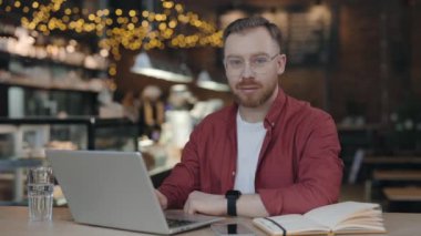 Kameraya bakan öğrencinin portresi Kafede zevkle gülümsüyor.