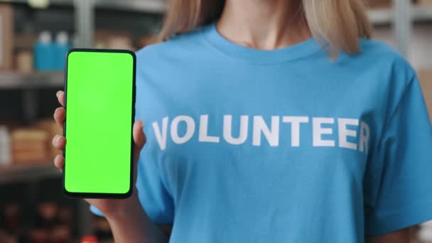 Zbliżenie wolontariusza pokazującego telefon komórkowy z ekranem klawisza chroma — Wideo stockowe
