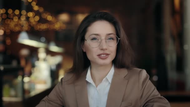 Attraente donna in abbigliamento formale sorridente sulla macchina fotografica al caffè — Video Stock