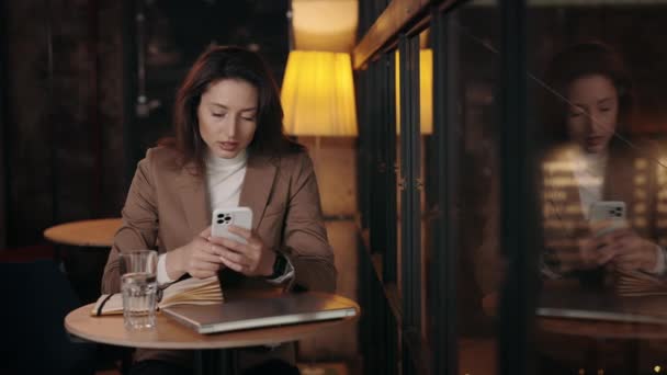 Γυναίκα σε επίσημη ένδυση χρησιμοποιώντας smartphone σε μοντέρνο καφέ — Αρχείο Βίντεο