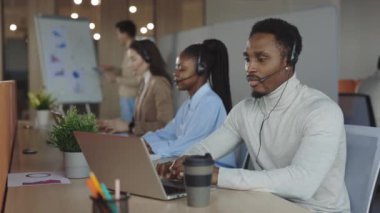 Merkezi ara. Servis telefon operatörleri müşteriyle indirimli telefon hattında görüşüyor. Ajans ofisinde yakın çekimde meşgul satıcı. Yardımcı müşteri hizmetleri desteği.