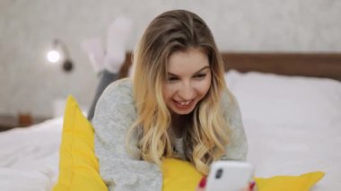 Güzel beyaz kadın akıllı telefon kullanıyor ve hafta sonunu gülerek geçiriyor..