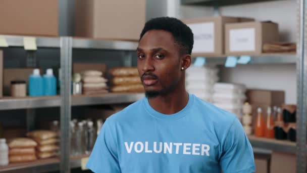 African american volunteer posing among food bank warehouse — Video