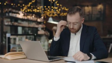 Girişimci, baş ağrısı çekerken gözlüğünü ve alnına masaj yapıyor..