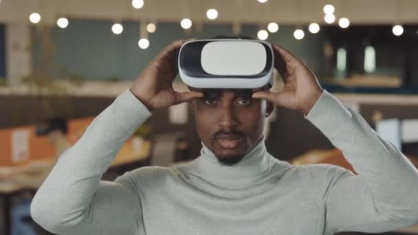 Manlig kontorsarbetare med VR-headset och virtuell verklighet. Porträtt av afrikansk amerikansk mjukvaruutvecklare stående i kontorsrummet. Det, företag och ny teknik koncept. — Stockvideo