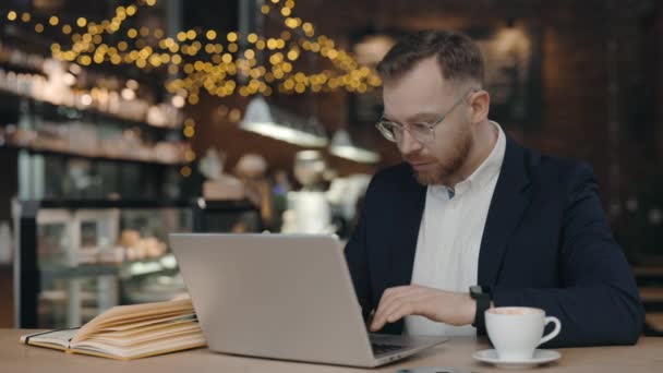 Affärsman som skriver på laptop. Man använder dator när man sitter på caféet — Stockvideo