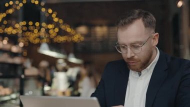 Kafede oturan bir iş adamı, iş sırasında baş ağrısı çekiyor..