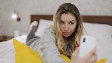 Bir kadın selfie çekiyor ve sonrasında ona bakıyor. İnsanlar ve aletler kavramı.