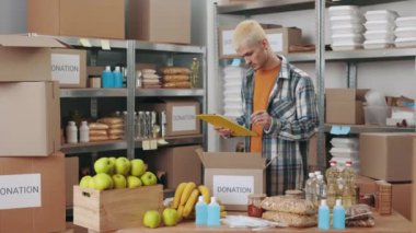 Elinde pano olan bir adam bağış kutularını paketliyor.