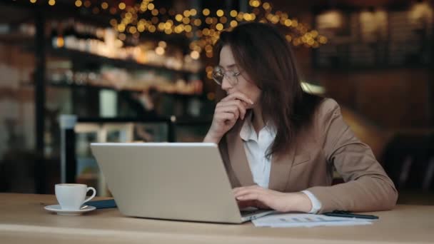 Frau tippt auf Laptop und hustet im Café — Stockvideo