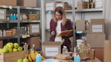 Bağış kutuları paketlenirken not alan gönüllü bir kadın.