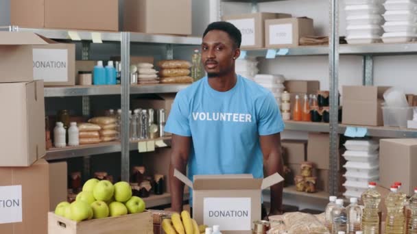 Africano americano homem preparando caixas para doação — Vídeo de Stock