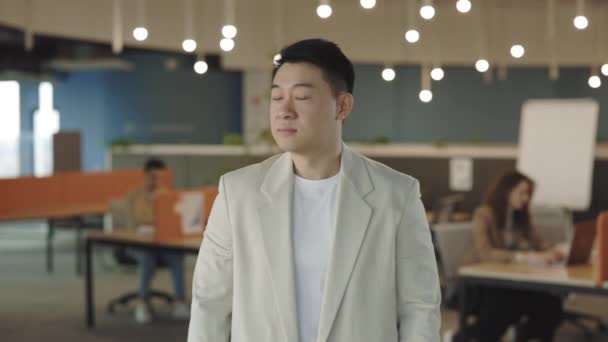 Succesvolle Aziatische business manager kijkend naar de camera die op een technologiebedrijf staat, gekruist armen. Mensen portretten. Wazige kantoorachtergrond. — Stockvideo