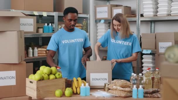 Zwei Ehrenamtliche bereiten Spendenboxen vor — Stockvideo