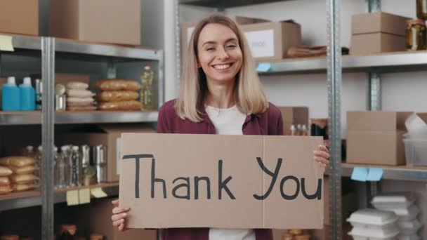 Tersenyum relawan wanita memegang terima kasih spanduk di tangan — Stok Video
