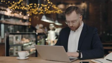 Kafede oturan ve dizüstü bilgisayarında yazan bir iş adamı. İş konsepti.