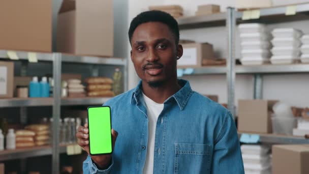 Afrikanischer Freiwilliger hält Handy mit grünem Bildschirm — Stockvideo