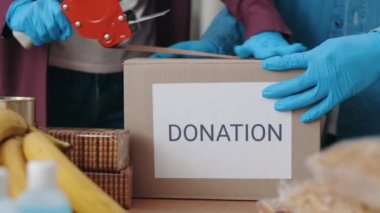 Eldivenli sosyal görevliler paketleme ve karton kutu yapıştırma