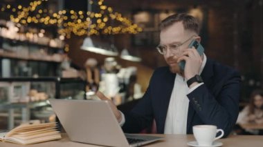 İş adamı, iş arkadaşıyla akıllı telefondan konuşuyor, tartışıyor. Kızgın yönetici..