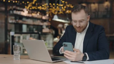 İş adamı akıllı telefondan mesaj atıyor. Heyecanlı adam iyi bir sözleşme imzalıyor..