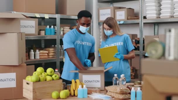 Voluntarios con portapapeles en las manos trabajando en el banco de alimentos — Vídeos de Stock