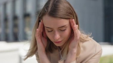 Yoğun bir iş gününden sonra dışarıda oturan çok bunalmış bir yönetici.