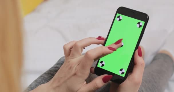 スマートフォンの緑色のクロマキー画面に指で入力する女性 手に女性の携帯電話 タッチ タップ クロマキー画面を緑色のモックアップ 閉じろ — ストック動画