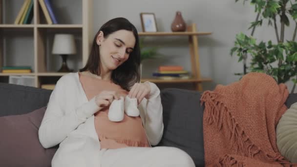 Feliz Futura Madre Sosteniendo Pequeños Zapatos Bebé Vientre Mientras Está — Vídeo de stock