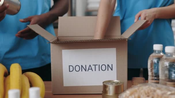 Voluntarios Voluntarias Llenando Cajas Cartón Con Comida Mientras Trabajan Juntas — Vídeos de Stock