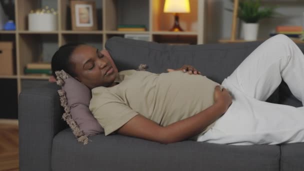아프리카 미국인 임산부가 소파에서 수면을 취하고 있습니다 미래의 어머니 가집에서 — 비디오