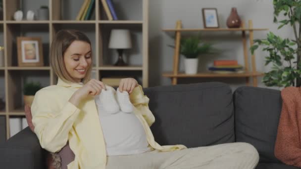 Positieve Blanke Vrouw Die Babyschoenen Haar Buik Houdt Terwijl Een — Stockvideo