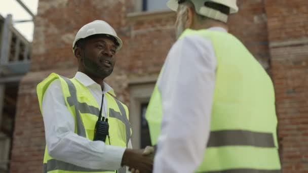 Afrykański Amerykański Architekt Podający Rękę Kaukaskiemu Budowlańcowi Placu Budowy Dwóch — Wideo stockowe