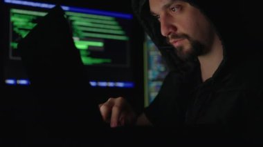 Genç erkek ağ hırsızı karanlık yeraltı sığınağından şirket veri sunucularına giriyor. Siber suç işlemek için dizüstü bilgisayar kullanan beyaz sakallı hacker..