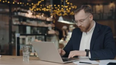 Orta yaşlı işadamı, klavye başında yazı yazıyor ve kafede çalışırken öksürüyor. Hasta bir çalışan iş günü boyunca kendini kötü hissediyor.