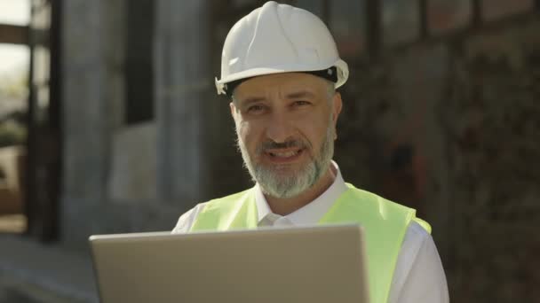 Ciężko Pracujący Męski Budowniczy Uśmiechający Się Kamery Podczas Pracy Bezprzewodowym — Wideo stockowe