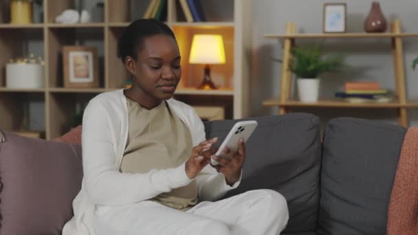 아프리카 미국인 소파에서 스마트폰을 사용하는 갑자기 느낀다 임신중의 기분의 — 비디오