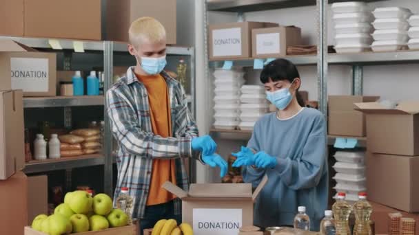Pozytywny Młody Mężczyzna Kobieta Maskach Medycznych Gumowych Rękawiczkach Podczas Pakowania — Wideo stockowe