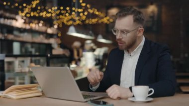 Sinirli iş adamı bilgisayar başında çalışırken görüntülü konuşma şirket sorununu çözüyor, tartışıyor. Sinirli yönetici teknik desteğe konuşuyor. Yazılım arızası hakkında soru soruyor.