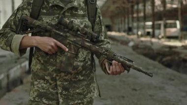 Askerlerin elinde kamuflaj silahlarını kapatın. Başarılı bir görevden sonra terk edilmiş binada yürüyen üniformalı tanınmamış bir asker..