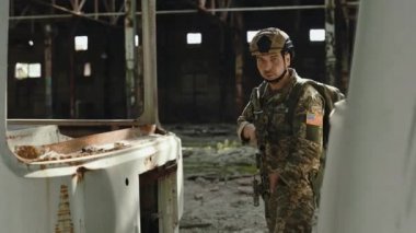 Amerikan askerinin portresi çökmüş binanın içindeki askeri operasyonda yer alıyor. Üniformalı, makineli tüfekli, fabrikanın bölgesini savunan kendinden emin bir adam..
