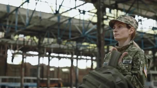겁없는 여자가 배낭을 탄약을 어깨에 이보입니다 파괴된 공장에서 걸어오는 군복을 — 비디오